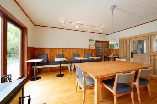 - une salle à manger avec une table et des chaises en bois dans l'établissement ハハハホステル, 