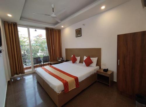 a bedroom with a large bed and a large window at Shivansh Inn Resort in Rishīkesh