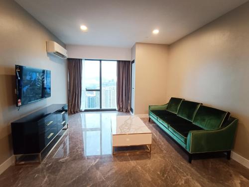 a living room with a green couch and a tv at Platinum 2 KLCC NewLuxuryCondo By Langitel with InfinityCityView SwimmingPool in Kuala Lumpur