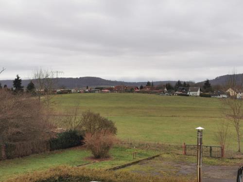 a large green field with a town in the background at Zur langen Heide in Hildburghausen