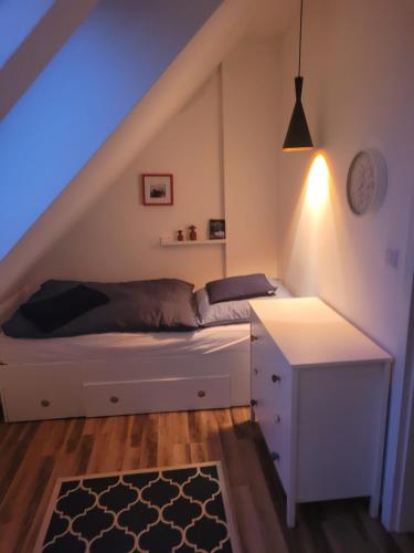a bedroom with a bed with a desk and a staircase at Haus Nathalie in Trzęsacz