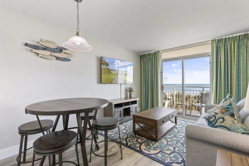 a living room with a table and a couch at Oceanfront Condo in Atlantica Resort near Boardwalk in Myrtle Beach
