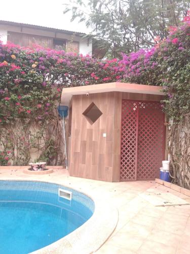 una piscina en un patio con flores rosas en La chambre diambar en Saly Portudal