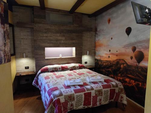 1 dormitorio con 1 cama y una pintura en la pared en Maison Manu, en Perosa Argentina