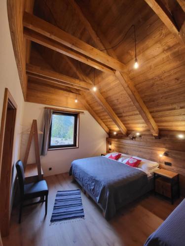 ein Schlafzimmer mit einem Bett und einer Holzdecke in der Unterkunft Hillview Jasná Chalet in Demänovská Dolina