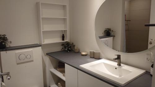 ein weißes Badezimmer mit einem Waschbecken und einem Spiegel in der Unterkunft Exclusive Waterfront Apartment - 12th Floor in Kopenhagen