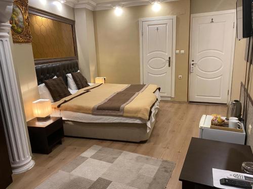 a bedroom with a large bed and a desk and a table sidx sidx at Lena Central Flats in Bursa