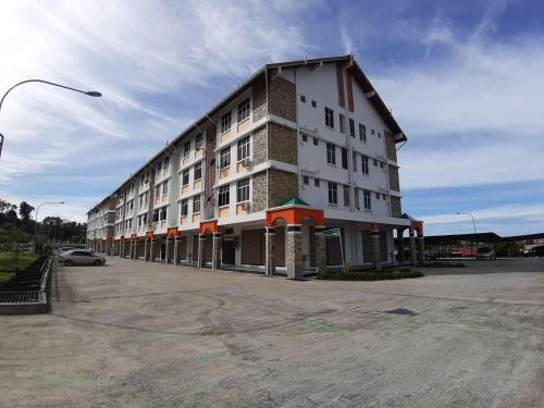a large building on a street with a parking lot at KW HOMESTAY CASA UNO APARTMENT in Sandakan