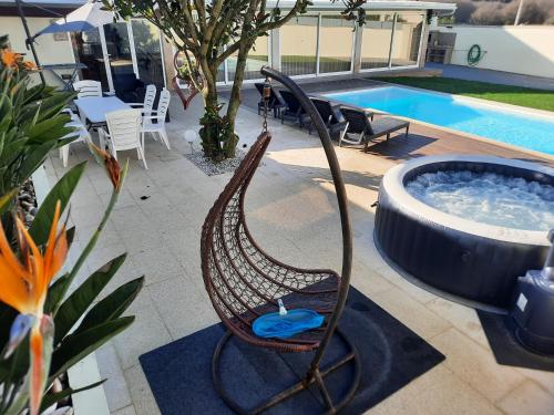 a rocking chair next to a hot tub next to a pool at Michel's house in Esposende