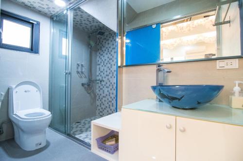 a bathroom with a blue sink and a toilet at Little SkyLark B&B in Magong