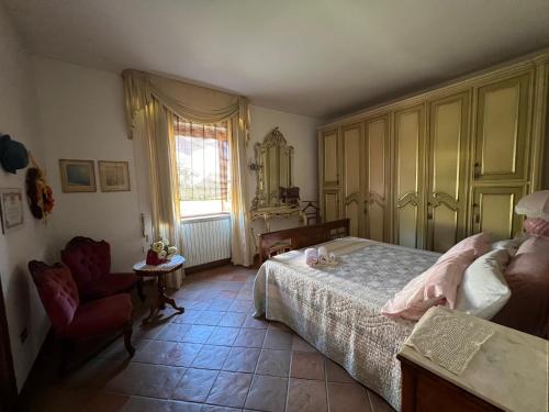 1 dormitorio con 1 cama, 1 silla y 1 ventana en A casa di Giò, en Fuscaldo