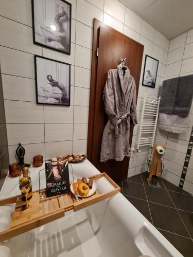ein Badezimmer mit einer Badewanne und einem Buch auf einem Regal in der Unterkunft Mountain Peak Apartment in Borowez