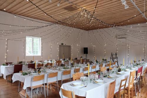 um grande salão de banquetes com mesas e cadeiras brancas em Stocklycke Omberg em Omberg