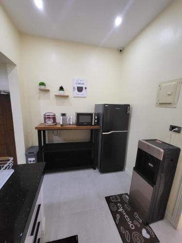 a kitchen with a black refrigerator and a table at Luxury 3BR Villa w Plunge Pool near SM Batangas City- Instagram-Worthy! in Batangas City
