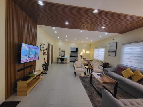 a living room with a couch and a tv at Luxury 3BR Villa w Plunge Pool near SM Batangas City- Instagram-Worthy! in Batangas City
