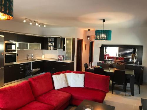 salon z czerwoną kanapą i kuchnią w obiekcie Peramos Luxury w mieście Néa Péramos
