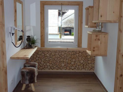 Zimmer mit einem Fenster mit einem Stapel Holz in der Unterkunft Glätzle`s Ferienhaus in Zöblen