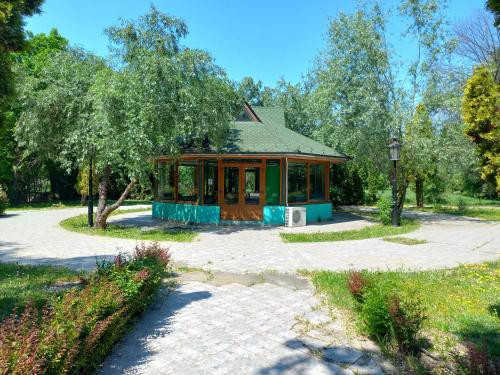 a small house in the middle of a park at Garni Hotel Lupus in Kanjiža