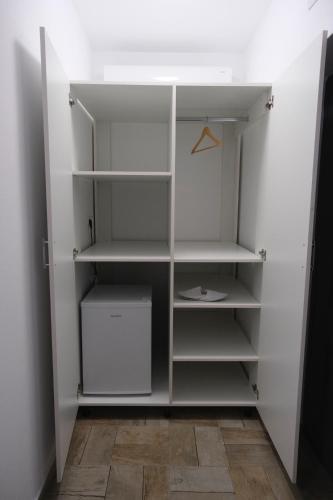 una cabina armadio con scaffali bianchi di Solomon Apartments Room nr 5 a Sângeorgiu de Mureș