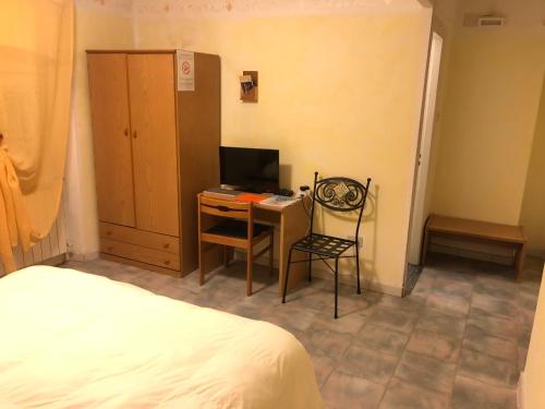 Campo LigureにあるAlbergo Ristorante Turchinoのベッドルーム1室(デスク、コンピュータ、ベッド1台付)