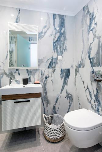 a bathroom with a toilet and a sink and a mirror at Pelagia Apartment by Kormaris in Kassiopi