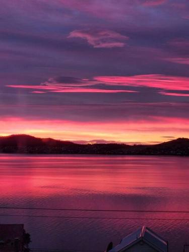 a sunset over a large body of water at Luxury and Spacious Modern House, Spectacular View in Sandy Bay