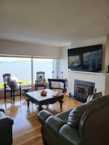 a living room with a couch and a fireplace at Luxury and Spacious Modern House, Spectacular View in Sandy Bay