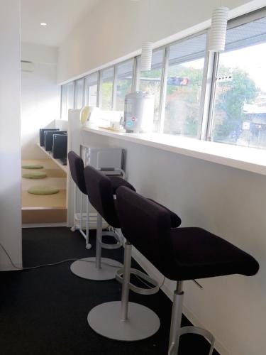 an office with chairs and a counter with windows at Santiago Guesthouse Kyoto in Kyoto