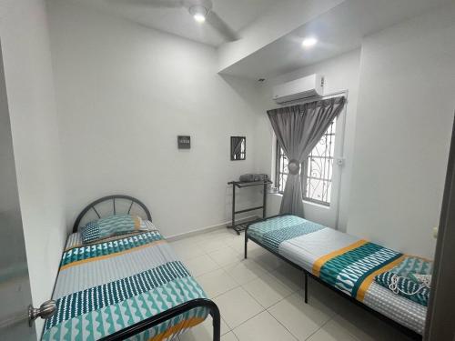 dwa łóżka w pokoju z oknem w obiekcie KUL Rest House w mieście Labu