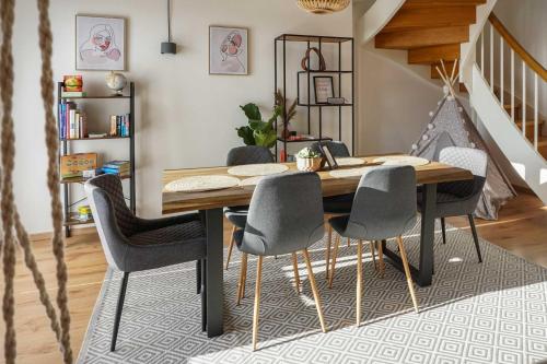 a dining room with a wooden table and chairs at Hejm Apart - Maisonette-Ferienwohnung "Alpspitze" in Mering