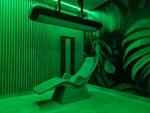 a green room with a green chair in front of a plant at Hotel 365 in Kielce