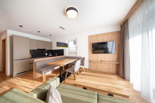 a living room with a wooden table and a kitchen at A CASA Granat in Sölden