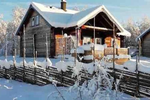 Una cabaña de madera en la nieve con nieve. en Cabin in Bruksvallarna, en Bruksvallarna