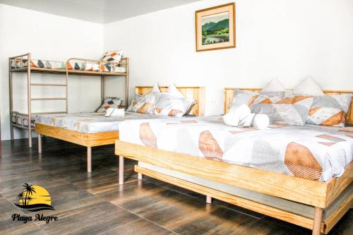 a bedroom with two beds and a bunk bed at Playa Alegre Beach Resort & Restaurant in Tanauan