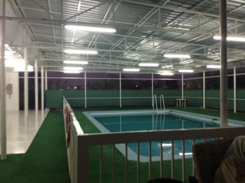 a swimming pool in a building with a tennis court at Safadi Farm in Adh Dhayd