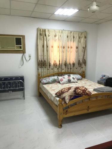 a bedroom with a wooden bed in a room at Safadi Farm in Adh Dhayd