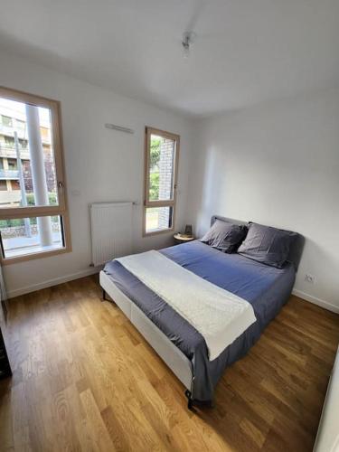 une chambre avec un grand lit dans une pièce blanche dans l'établissement Lyon Part-Dieu superbe appartement 2 chambres, à Lyon
