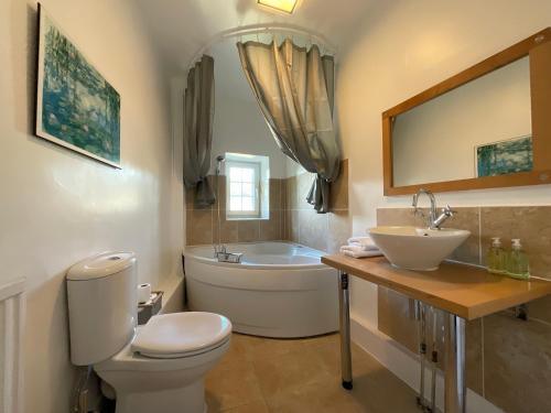 een badkamer met een toilet, een wastafel en een bad bij Large 4 double bedroomed townhouse in central Holmfirth in Holmfirth