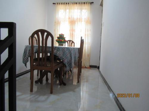 uma sala de jantar com uma mesa e cadeiras e uma janela em pumindu homestay em Matara