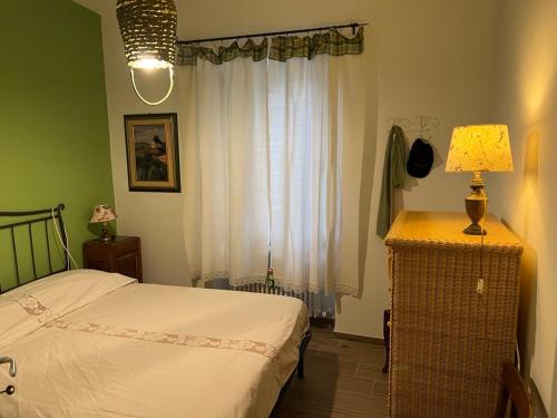 1 dormitorio con cama, lámpara y ventana en fuga sui sibillini en Gualdo di Macerata