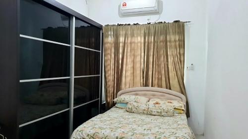 a small bedroom with a bed and a closet at Homestay Ahmad Kuala Kangsar in Kuala Kangsar