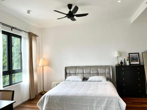 a bedroom with a bed with a ceiling fan at Ipoh Peaceful Onsen studio Lost World Tambun in Tambun