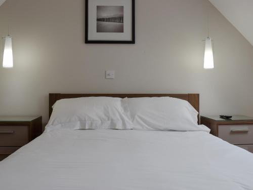 a bedroom with a white bed with two night stands at Hollies Cottage 14 -ukc4537 in Martock