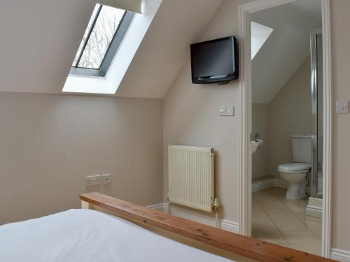 a bedroom with a bed and a tv on the wall at Hollies Cottage 14 -ukc4537 in Martock