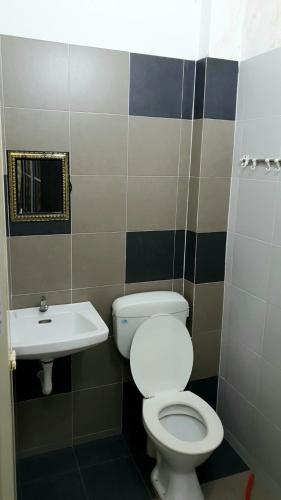 a bathroom with a toilet and a sink at Homestay Ahmad Kuala Kangsar in Kuala Kangsar