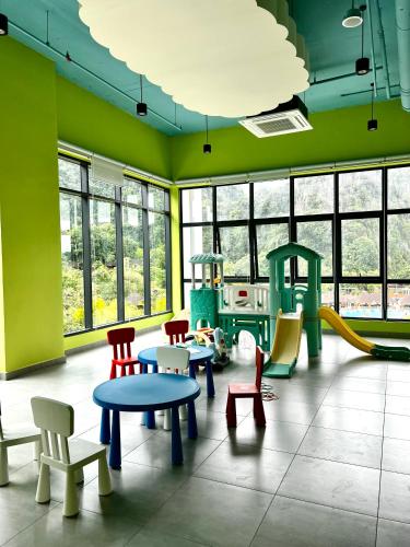 a room with colorful chairs and tables and a playground at Ipoh Peaceful Onsen studio Lost World Tambun in Tambun