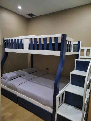 a bunk bed with a ladder next to a bunk bedutenewayewayangering at Luxury 3BR Villa w Plunge Pool near SM Batangas City- Instagram-Worthy! in Batangas City