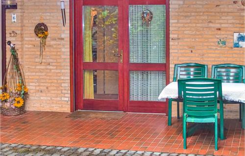 einen Tisch und Stühle auf einer Terrasse mit einer roten Tür in der Unterkunft 1 Bedroom Awesome Home In Prmzurlay in Prümzurlay