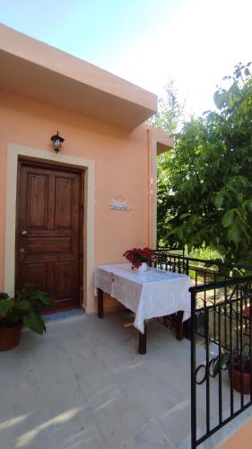 a table in front of a house with a door at Potami Studios in Lefkímmi