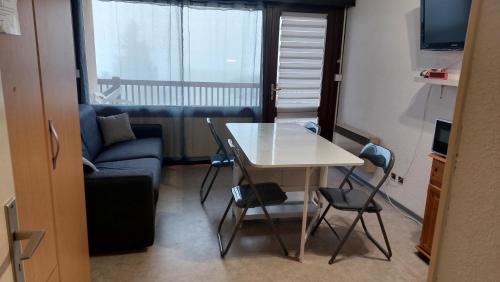 un petit salon avec une table et un canapé dans l'établissement Font-Romeu : Studio cabine avec terrasse., à Font-Romeu-Odeillo-Via